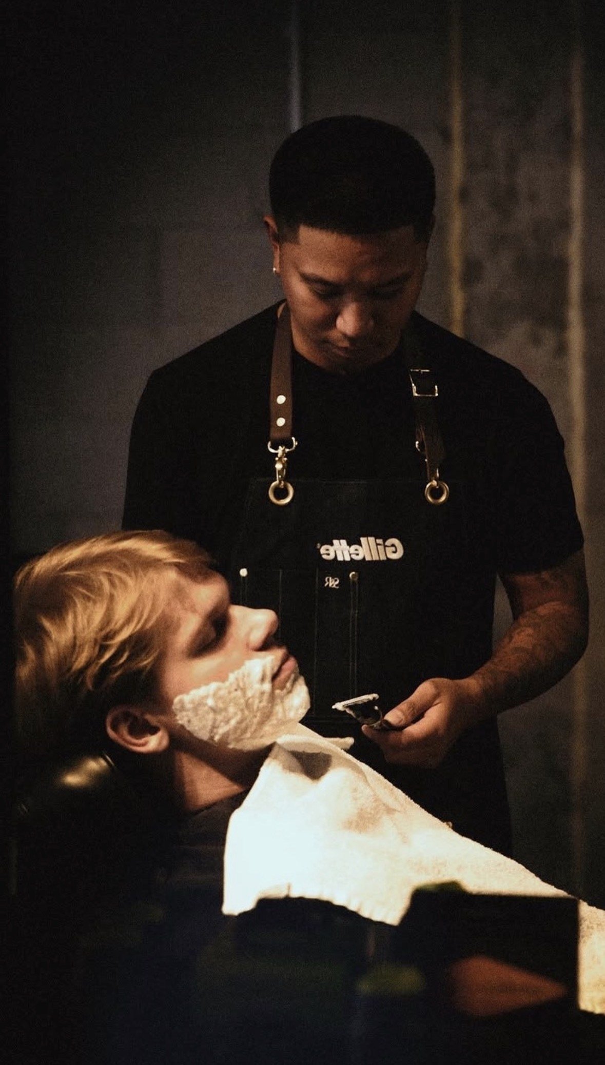 A Throne barber preparing a client for a shave
