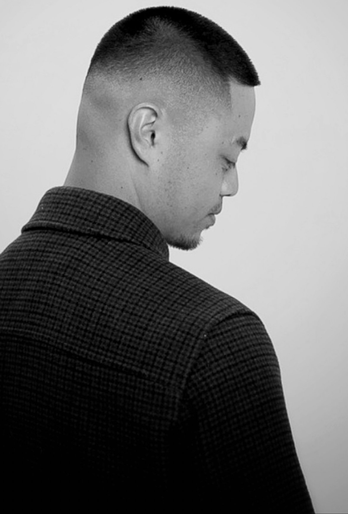 Black-and-white profile portrait of Marvin Palomo with a buzz cut looking down
