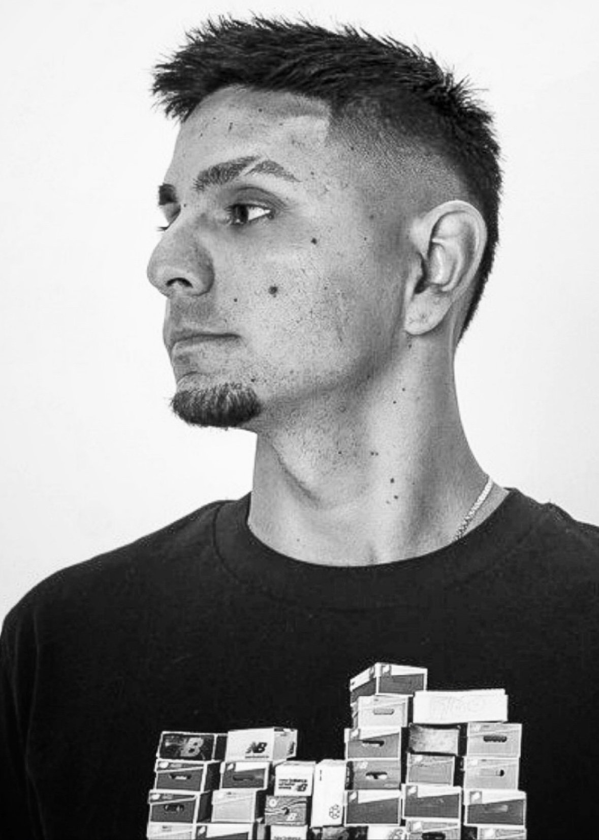 Black-and-white portrait of Andrés Giménez with a textured fade haircut looking left