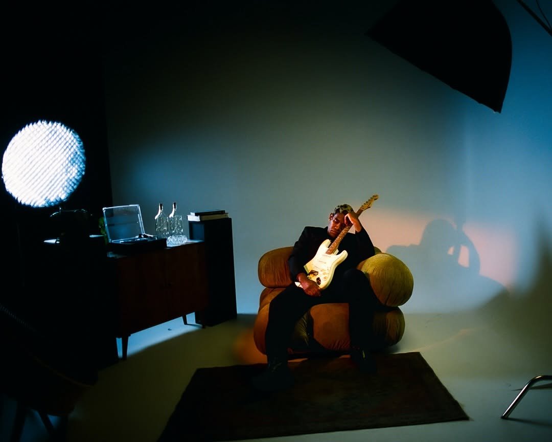 Musician with a guitar in the studio — photo by Adriano Clarke